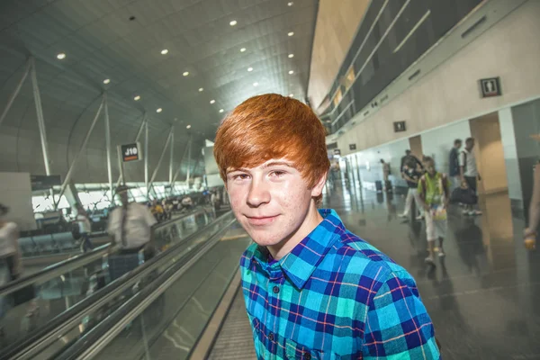 Jovem em uma escada em movimento dentro do aeroporto — Fotografia de Stock