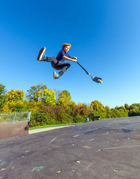 Kind fliegt mit Roller in die Luft — Stockfoto