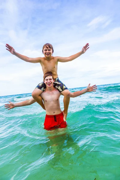 Irmãos se divertir no belo mar claro — Fotografia de Stock