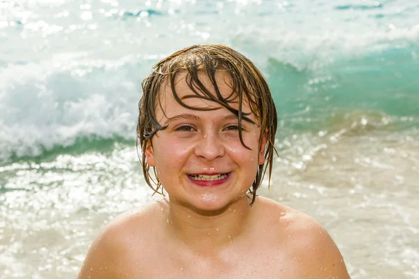 Chico se divierte con la tabla de surf en la playa —  Fotos de Stock