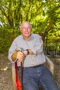 mutlu Bahçe sandalyesine oturmuş kıdemli gülüyor