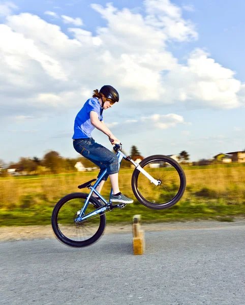 Jongen met zijn dirk fiets springen over een barrière op de stree — Stockfoto