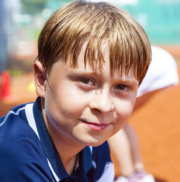 Çocuk tenis maç sonrası, mutlu ve memnun görünüyor. — Stok fotoğraf