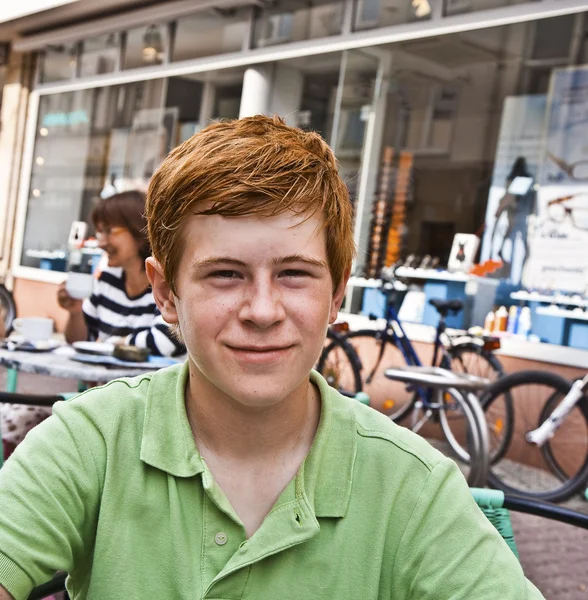 Kind met rood haar is op zoek gelukkig en vriendelijke zitten in een o — Stockfoto