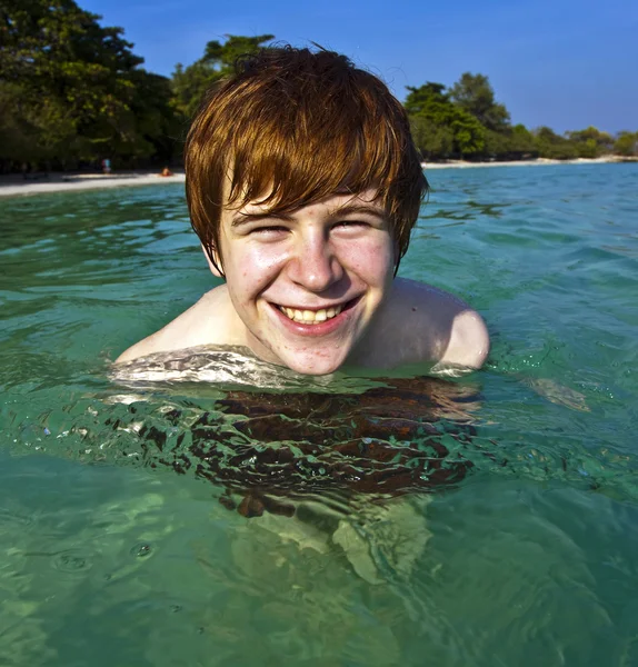 Ragazzo dai capelli rossi gode l'acqua cristallina nel mare — Foto Stock