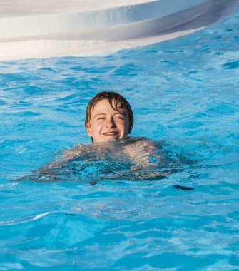 Havuzda yüzen çocuk.