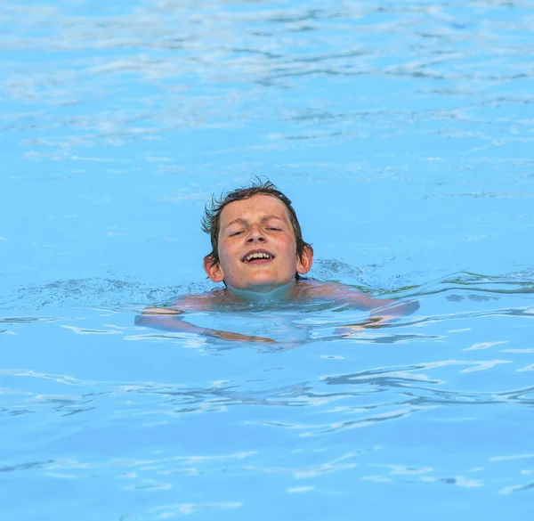 Pojke simmar i poolen — Stockfoto