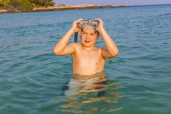Νεαρό αγόρι στην υπέροχη θάλασσα σαφή ξεκινά κολύμβηση με αναπνευστήρα — Φωτογραφία Αρχείου
