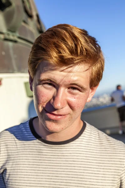 Porträt eines hübschen Jungen mit roten Haaren unter blauem Himmel — Stockfoto