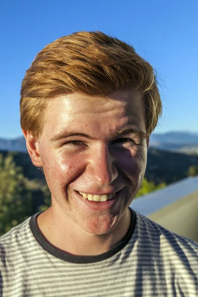 Портрет красивого мальчика с рыжими волосами под голубым небом — стоковое фото
