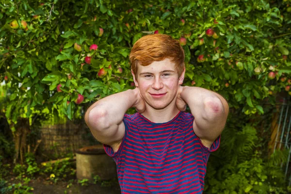 Aantrekkelijke gelukkig lachend jongen in de tuin — Stockfoto