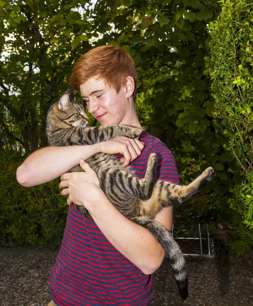 Ładny chłopak z Rude włosy z jego kot w ramię — Zdjęcie stockowe