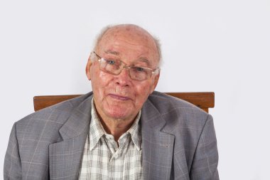 Koltuğunda oturan kendinden emin yaşlı bir adamın portresi.