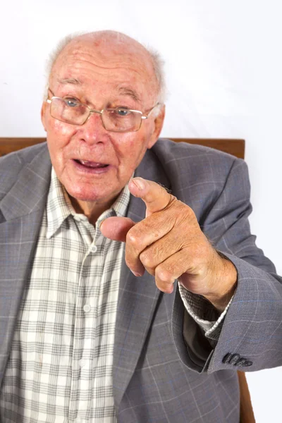 Äldre smart övertygad om man sitter i sin fåtölj — Stockfoto