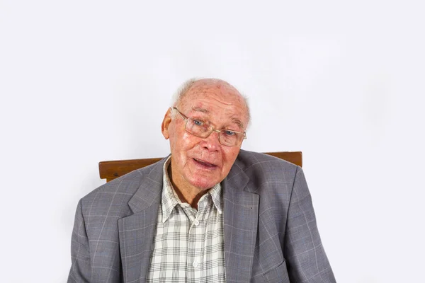 Elderly smart confident man sitting in his armchair — Stock Photo, Image