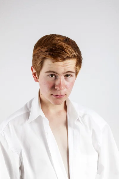 Young man buttons his white shirt — Stock Photo, Image