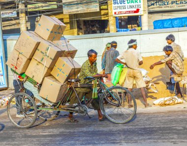 Rickshaw sürücü ağır yük sabah erken taşımaktadır.