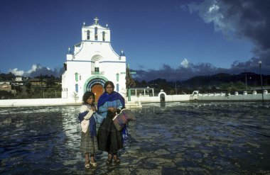 mother with child sells handmadensouvenirs at church of San Juan clipart