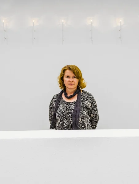 Attraktive Dame, die mit weißer Weste auf einem Balkon im Museum spaziert — Stockfoto