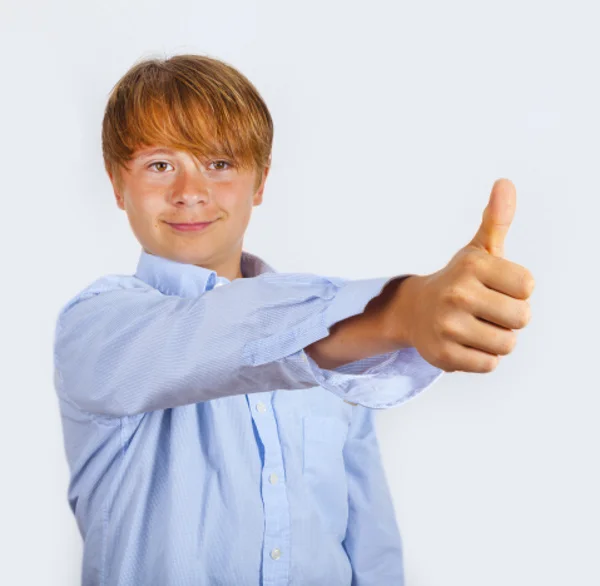 Bonito jovem feliz menino no estúdio mostra eu gosto dele assinar com seu thu — Fotografia de Stock