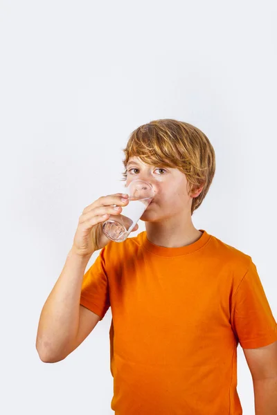 Lindo chico con camisa naranja bebe agua — Foto de Stock