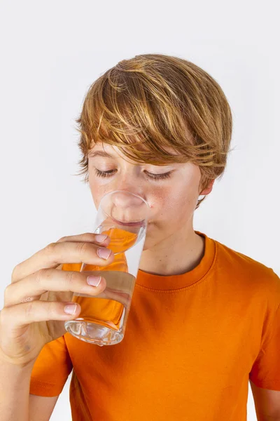 Rapaz bonito com camisa laranja bebe água — Fotografia de Stock