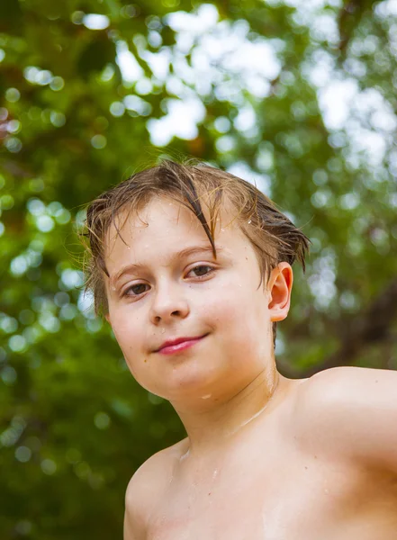 Chlapec s mokrými vlasy přichází z moře andsmiling a vypadá sebevědomý — Stock fotografie