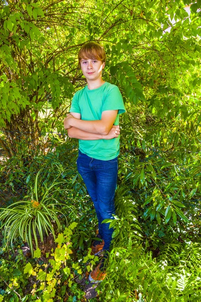 Leuke slimme jongen in de tuin onder de boom — Stockfoto