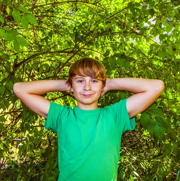 Cute smart boy in the garden under the tree — Stock Photo, Image