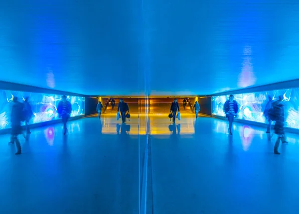 Tunnel with pedestrians in motion in blue cool light — Stock Photo, Image