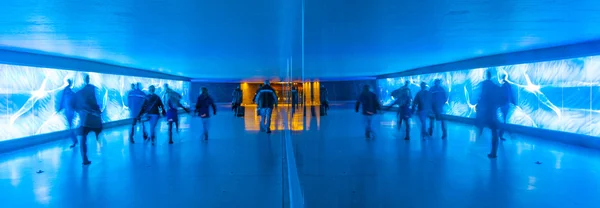 Tunnel with pedestrians in motion in blue cool light — Stock Photo, Image