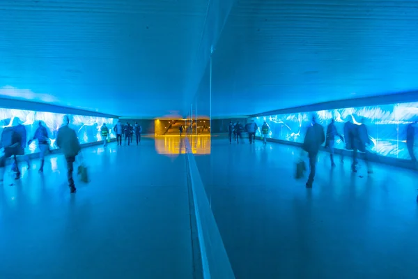 Tunnel with pedestrians in motion in blue cool light — Stock Photo, Image