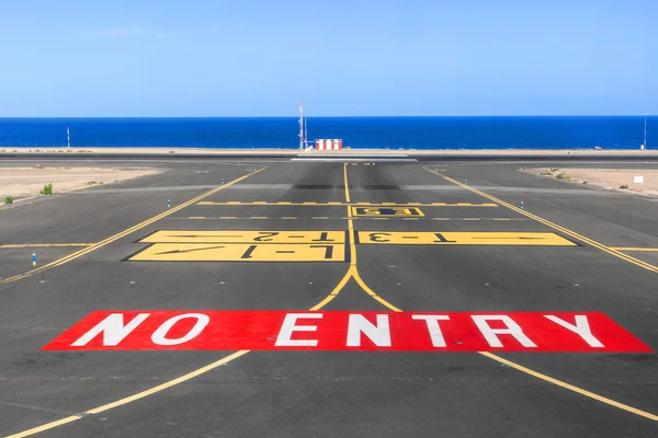 Nenhum sinal de entrada na pista do aeroporto com oceano no backgro — Fotografia de Stock