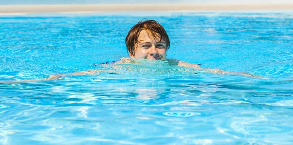 Süß hübsch teenager junge schwimmt im die pool — Stockfoto