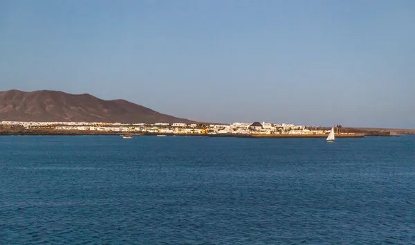 Plaats (town) en haven van playa blanca van zee in de avond — Stockfoto