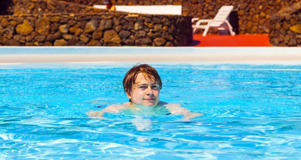 かわいいハンサムな 10 代の少年はプールで泳ぎます — ストック写真