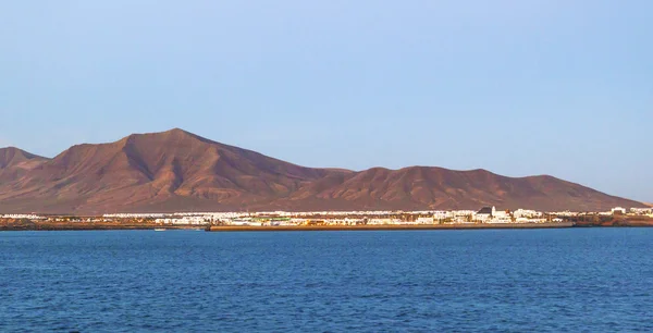 Staden och hamnen i playa blanca från havet på kvällen — Stockfoto