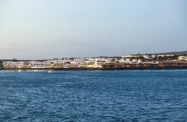 Staden och hamnen i playa blanca från havet på kvällen — Stockfoto