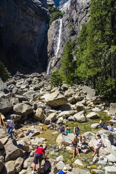 Tourists cool their legs in the lake of the lower Yosemite wate — Stock Photo, Image