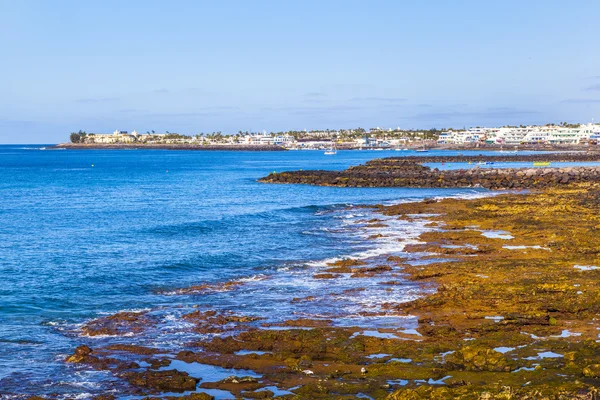 Pláž a vesnice Playa blanca s sopka montana roja — Stock fotografie