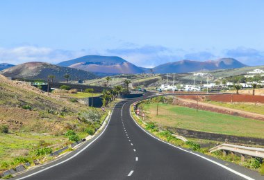 driving in Lanzarote with view to Timanfaya volcanoes clipart