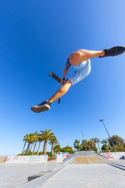 Çocuk skatepark onun scooter ile omurga atlar