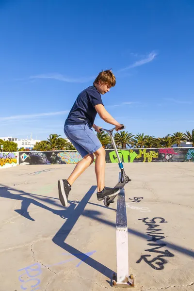 Jongen springt met zijn scooter over een helling — Stockfoto