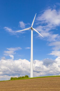 Mavi gökyüzü elektrik üreten bir rüzgar türbini