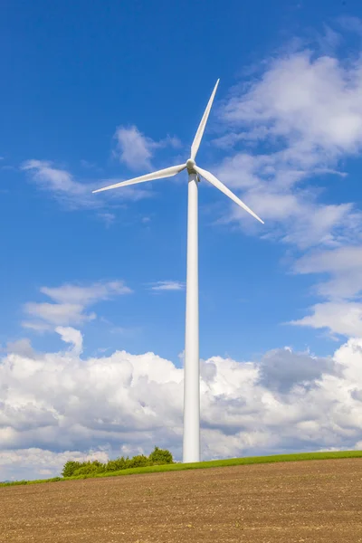 Vindturbin som produserer elektrisitet på blå himmel – stockfoto