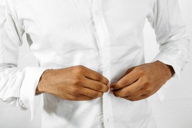 Gömleğinin düğmelerini ilikleyen adam