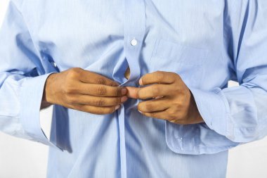 Gömleğinin düğmelerini ilikleyen adam