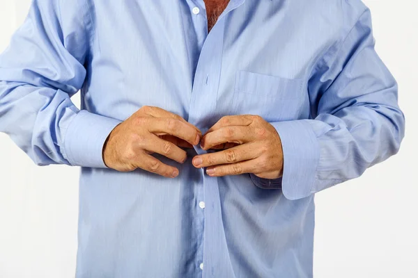 Een man knoopt zijn shirt dicht. — Stockfoto