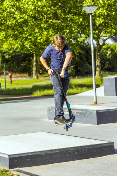 Pojken har kul rida sin push skoter — Stockfoto