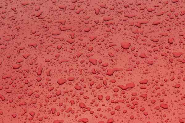 Padrão vermelho de gotas de chuva em uma superfície metálica — Fotografia de Stock